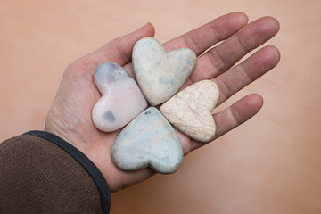 female hand with four-leaf soapstone clover, wooden background