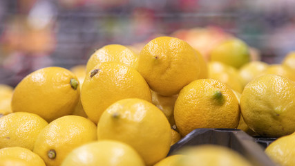 Colorful Display Of Lemons in a basket at bio market or grocery store. Organic Fresh lemons background close up