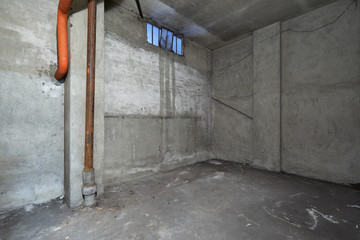 Empty basement interior with concrete walls