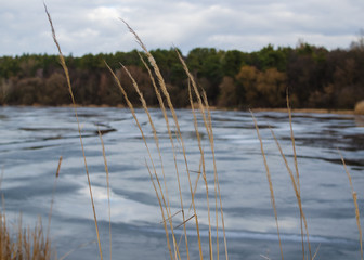 Tranquil lake scene with snow during early spring. Spring landscape. Lake, melting ice, forest