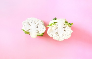 Two half head fresh organic cauliflower on a bright pink background. Minimalistic, natural,...