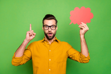 Portrait of nice attractive amazed intellectual guy in formal shirt holding in hand red empty blank card found solution pointing up isolated on bright vivid shine vibrant green color background