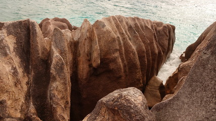 Eroded red granite rocks on a Seychelles island beach