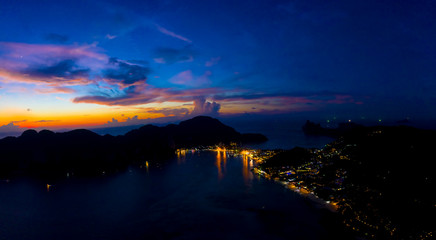 Aerial view of Phi Phi, Maya beach with blue turquoise seawater, mountain hills, and tropical green forest trees at sunset with Andaman sea in Phuket island in summer, Thailand in travel trip. Nature.
