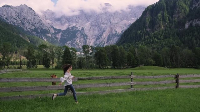 Carefree and happy girl running in mountain countryside