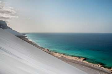 Top view from a sand dune on the coast of the Indian Ocean. exotic beautiful deserted island with a baked dune and views of the emerald coast. Socotra Yemen.