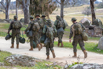 Fototapeta premium Troop of ground soldiers walking in the field