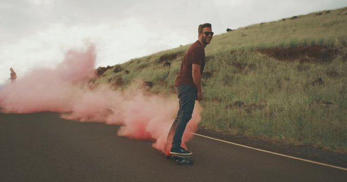 Three adventurous friends skateboarding together with colorful smoke grenade trails
