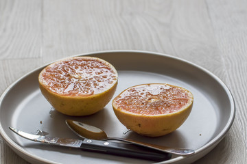 Fototapeta na wymiar Grilled grapefruit with curved grapefruit knife and spoon