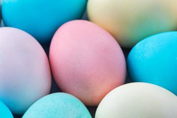 Colorful Easter eggs dyed by colored water isolated on a pale blue background, design concept of Easter holiday activity, close up, copy space.