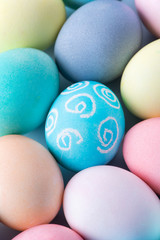 Colorful Easter eggs dyed by colored water isolated on a pale blue background, design concept of Easter holiday activity, close up, copy space.