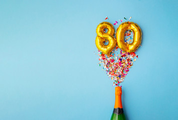 80th anniversary champagne bottle balloon pop - obrazy, fototapety, plakaty