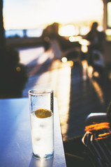 refreshing drink with lemon in a beach bar at sunset