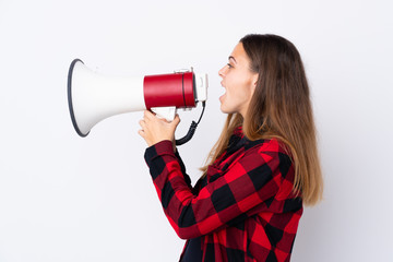 Teenager girl over isolated white background shouting through a megaphone