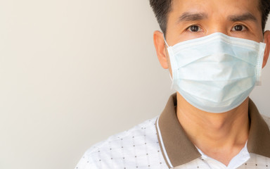 An Asian man using an infection preventive face mask on a white background with copy space for text or anything else.