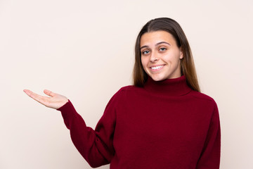 Teenager girl over isolated background extending hands to the side for inviting to come