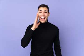 Young caucasian handsome man with turtleneck sweater isolated on purple background shouting with mouth wide open