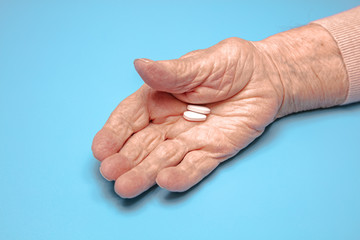 Close-up. old woman's hands are holding pills. Concept of illness, flu, old age, Coronavirus, help