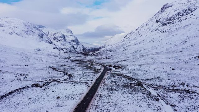 aerial drone footage of winter in glencoe and rannoch moor in the argyll region of the highlands of scotland showing clear bright white snow on the mountains of glencoe and the surrounding region