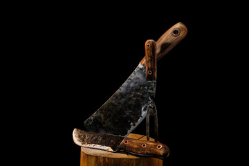 Rustic butcher meat knife, cleaver and fork on black background