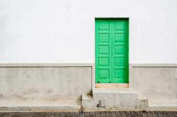 Naklejka na ściany i meble Green door and window wooden made in a white facade.