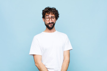 young bearded man with glasses against blue wall