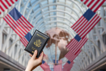 Woman hand holding american passport  in the Chocago airport with american flags. concept. America. USA
