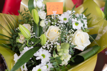 Bouquet of white flowers roses, lilies, gypsophila, chrysanthemums in the shop. Retail street sale near metro station for Valentine's Day on February 14 or International Women's Day on March 8