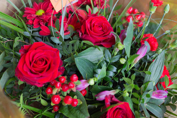 Bouquet of red flowers roses, carnations, ghypericum in the shop. Retail street sale near metro station for Valentine's Day on February 14 or International Women's Day on March 8