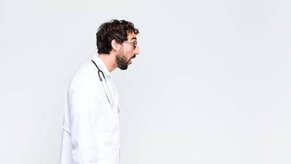 young crazy bearded doctor man against copy space wall