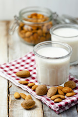 Fresh organic vegan almond milk. Alternative source of protein for vegetarians. Raw almonds as ingredients, peeled and unpeeled. Concept of healthy lifestyle. Closeup, wooden background
