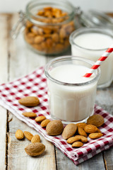 Fresh organic vegan almond milk. Alternative source of protein for vegetarians. Raw almonds as ingredients, peeled and unpeeled. Concept of healthy lifestyle. Closeup, white background.