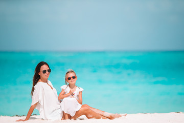 Beautiful mother and daughter at the beach enjoying summer vacation.