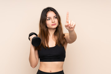 Young sport woman making weightlifting isolated on beige background touching on transparent screen