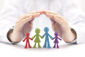 Fototapeta na wymiar Family insurance concept with colorful family figurines covered by hands