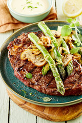 Grilled rump steak topped with green asparagus