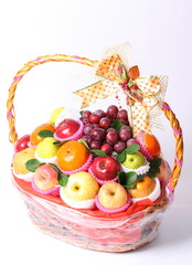 Different fruits in wicker basket isolated on white