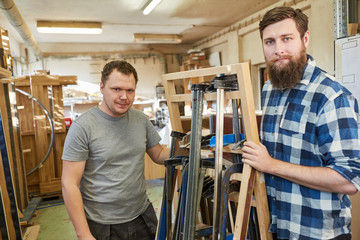 Zwei Tischler mit einer Auswahl an Schraubzwingen