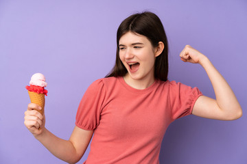 Young Ukrainian teenager girl holding a cornet ice cream over isolated purple background celebrating a victory