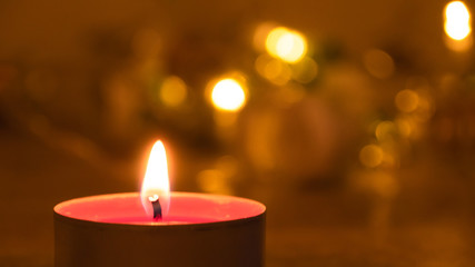 Close up of a red candle at night; an abstract background of candle