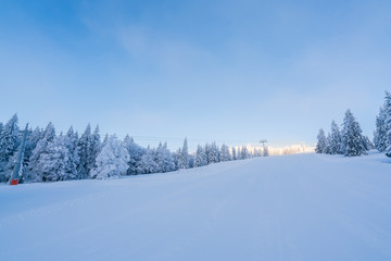 Fototapeta na wymiar Beautiful snowy ground scenery in winter against sunny weather and blue sky