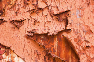 Cracked brown paint close-up. Background from a ragged wall in terracotta color.