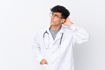 Young Argentinian man over isolated white background wearing a doctor gown and having doubts