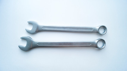 Two steel combination spanners lie on a white background.  Tools for repair.