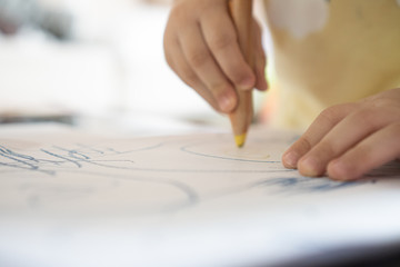 Close up hand of 2year kid use color pencil draw line on paper. Concept of art for children learning . Education and  imagination