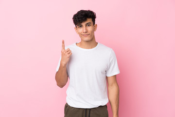 Young Argentinian man over isolated pink background pointing with the index finger a great idea