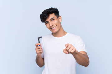 Man shaving his beard over isolated white background points finger at you with a confident expression