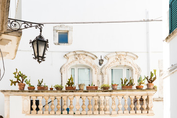 white house with balcony and cactus plants in Martina Franca, Italy - obrazy, fototapety, plakaty