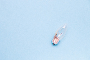 broken burned-out light bulb on a blue background copy space top view
