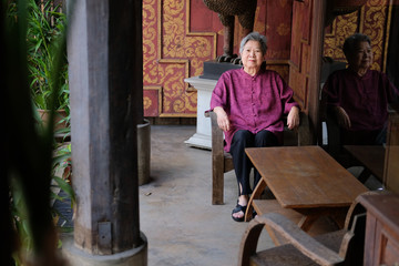 Obraz na płótnie Canvas old elderly senior elder woman resting relaxing on chair at balcony